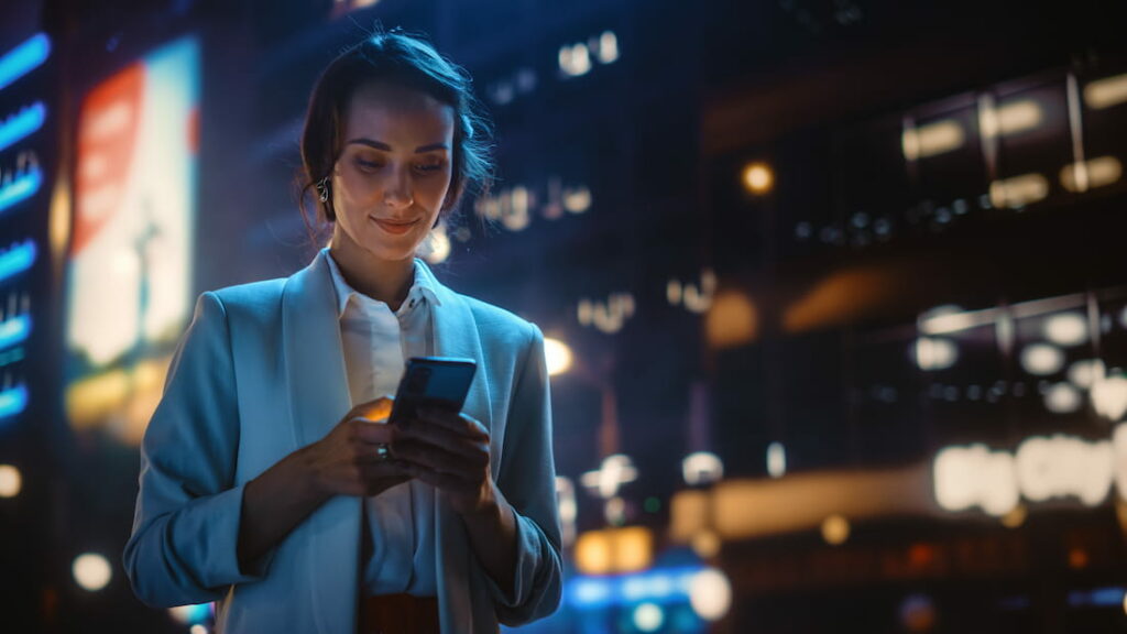 Frau benutzt ihr Smartphone, symbolisch für Remarketing im Hotelmarketing